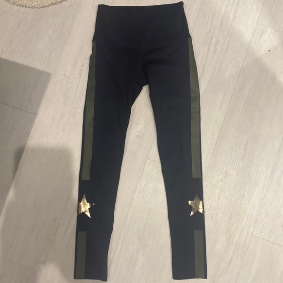 These are black leggings with a green streak and a star on both sides - Picture 1 of 3